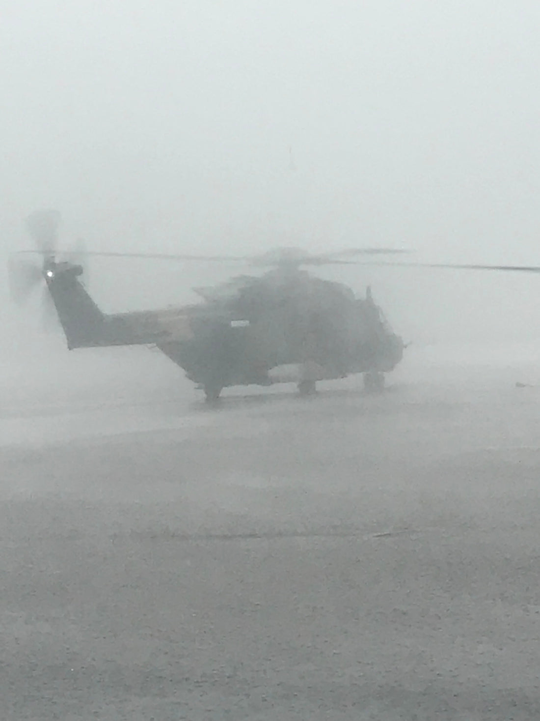 Helicopter delivering disaster relief supplies in heavy rain