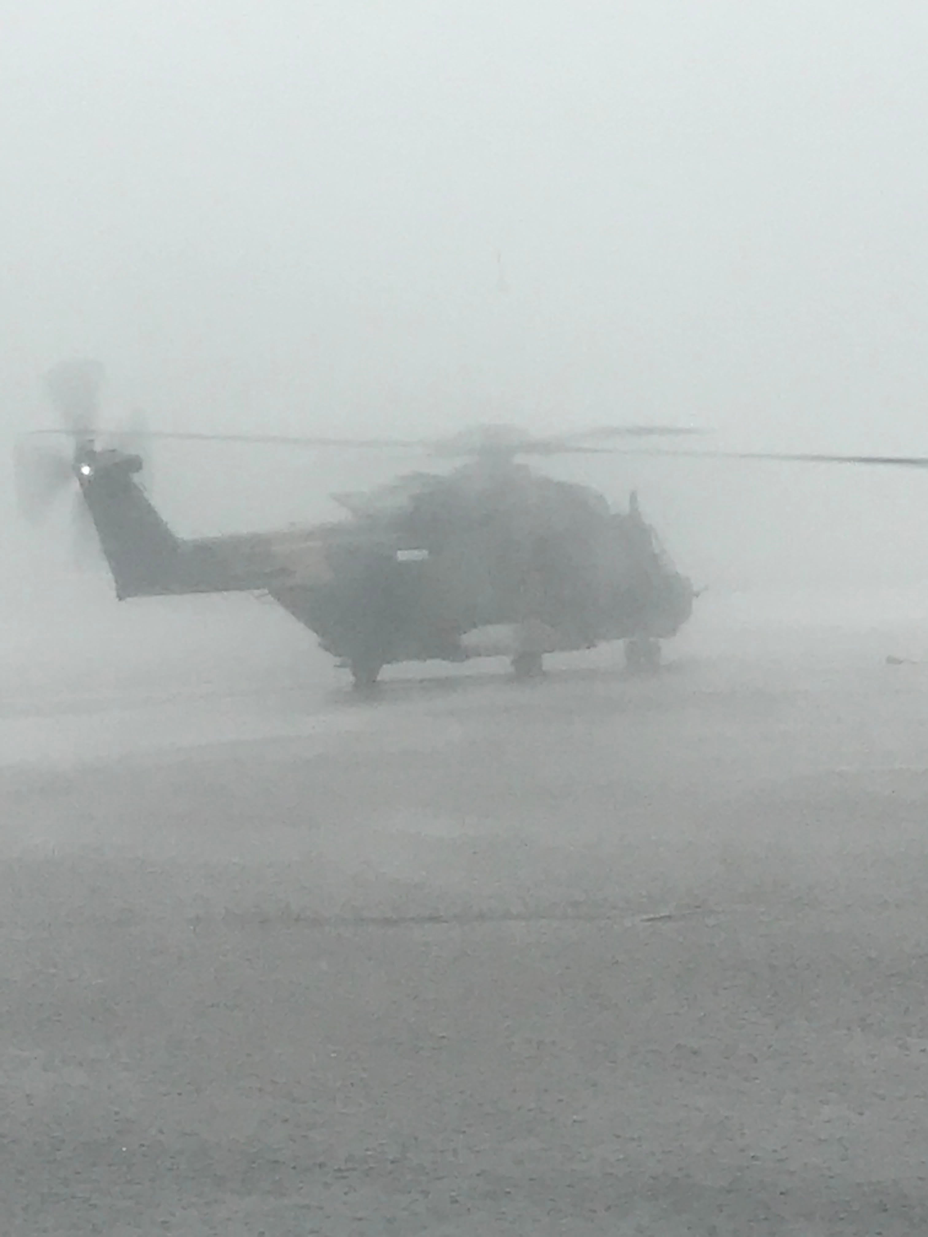 Helicopter delivering disaster relief supplies in heavy rain