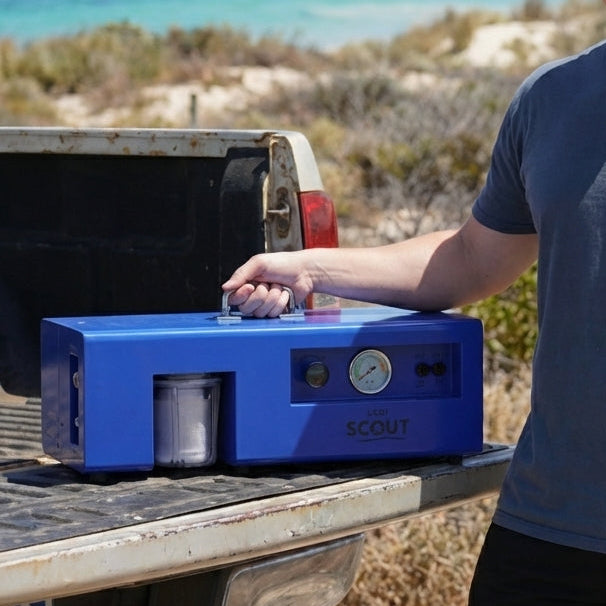 Man standing by a truck with a Scout watermaker in a coastal setting